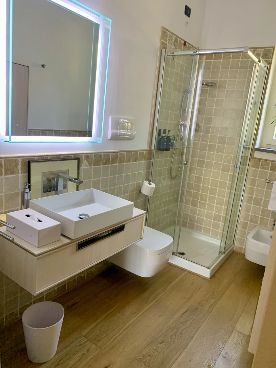 Il bagno con la specchiera illuminata e la doccia
