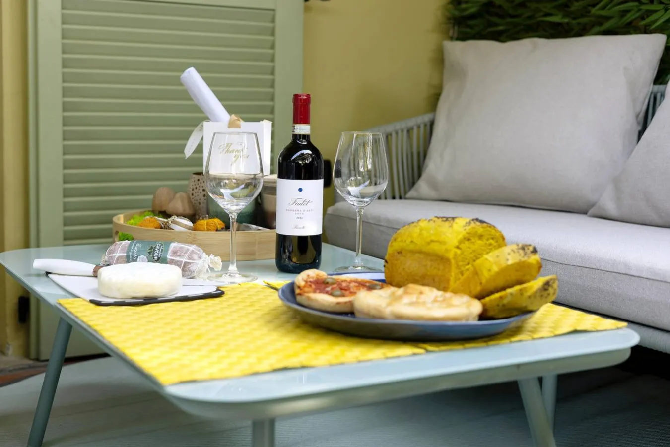 Vino rosso, torta, focaccia e formaggio sul tavolino del patio